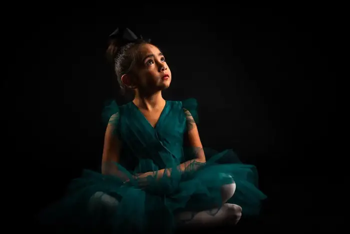 Dramatic studio portrait of young woman in teal dress Carlsbad NM